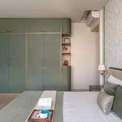 For this master bedroom in Thane, we aimed for simple sophistication. I built the custom wardrobe with curved edges and subtle gold accents to create a soft, luxurious feel. The entire room is designed to be a calm and warm space.