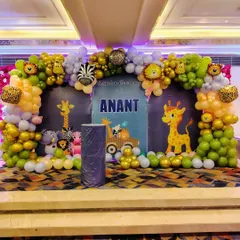 This is the main stage I designed for Anant's jungle-themed Mundan ceremony, which works wonderfully for a birthday party too. The backdrop features friendly giraffes and a custom name sign, framed by a spectacular balloon arch with animal print and character foil balloons.