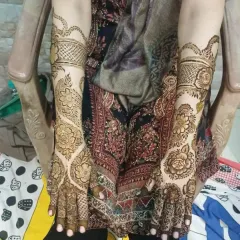 A classic full-hand and arm mehendi design, featuring beautiful floral patterns and detailed jaali (net) work on the wrists.