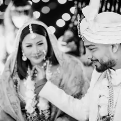 A tender black and white moment during the wedding ceremony, where the groom gently touches the bride's chin, filled with emotion.