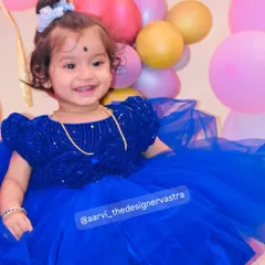 That happy smile says it all. The voluminous tulle skirt of the blue frock is perfect for a birthday celebration.