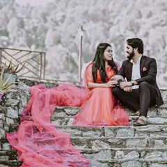 A destination pre-wedding shoot in the hills of Almora, Uttarakhand. The bride's flowing gown drapes down the stone steps, adding a touch of drama and romance to this beautiful mountain setting.