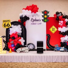 I bring high-speed fun with detailed racing themes. This "First Lap" setup features a custom track, road signs like Route 66, a traffic light, and of course, cool race cars for a picture-perfect party.