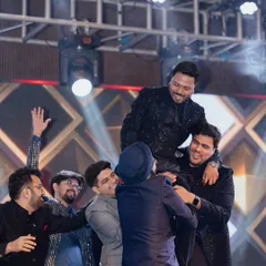 A classic 'groom on the shoulders' moment. These are the fun, unscripted celebrations that make a sangeet night so memorable for the groom and his friends.