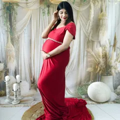 A graceful portrait in our boho-chic studio. The mom-to-be is wearing a simple yet elegant red gown, creating a timeless and romantic look.