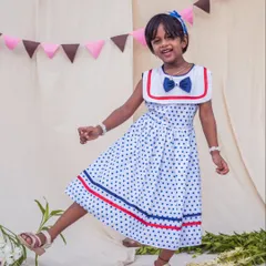 A joyful leap in a fun polka dot dress. This image captures the carefree spirit of childhood, and the dress is designed to move with her through every happy moment.