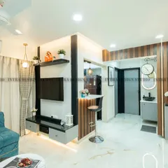 We designed this modern living room with a dark grey molded feature wall for a touch of drama. The space includes a breakfast counter that connects to the open kitchen, blending comfort and style.