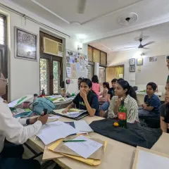 An interactive session in progress. Here, a guest artist is reviewing student work and providing valuable feedback, creating a dynamic learning environment.