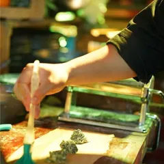 A chef brushes an egg wash onto the pasta sheet, preparing to seal the ravioli. This step ensures the filling is perfectly enclosed before cooking, a small but crucial detail in our fresh pasta-making process.