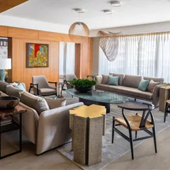 Another view of the Magnolia living area, highlighting the flow of the space. The arrangement of bespoke sofas, armchairs, and sculptural side tables creates multiple conversation zones. The design ensures that whether you are relaxing or entertaining, the room feels both grand and intimate.