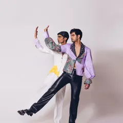 A duplicate of image 51, this shot for the "Monsieur" collection highlights the playful interaction between the models. The styling combines classic tailoring with bold prints and unconventional materials like faux leather.