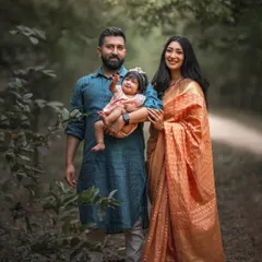 This family portrait, with the mother's elegant saree and the lush green background, has a timeless, classic feel. It’s a beautiful representation of a family's heritage and love.
