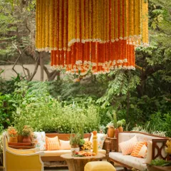 Marigolds, or 'genda', are my absolute favorite, and for this Haldi, I used them in abundance. These stunning chandeliers, made entirely of marigold strings, hung over intimate seating areas, immersing the garden venue in warmth and vibrancy.
