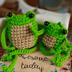 A pair of cheerful green frogs to brighten your day. These little amigurumi friends, with their big eyes and friendly smiles, are perfect as desk buddies or a cute gift to remind someone to be awesome.