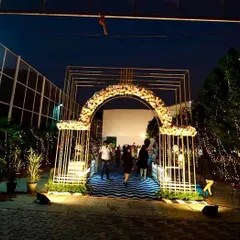 The grand entrance for the 60th birthday party. We fabricated this geometric tunnel arch with floral details, leading guests down a custom-printed carpet into the event space.