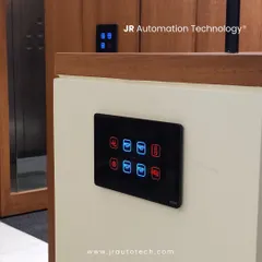 Our touch panels are designed to complement any architectural style. Here, a black glass panel is installed against both a white wall and a rich wood-paneled surface, showing its versatility and how it adds a modern touch to the space.
