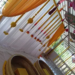 A top-down view showing the details of the Haldi decor, including the hanging umbrellas and the marigold strings over the seating area.