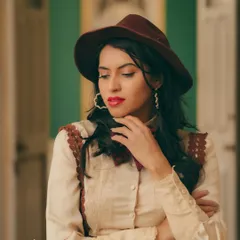A closer portrait from the same vintage shoot, focusing on the model's contemplative expression and styling details like her hat and red lipstick. The warm, film-like color grading adds to the nostalgic and fashionable mood.