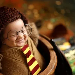 A heartwarming close up of a sleeping newborn, peacefully dreaming of magic. The tiny glasses and Gryffindor scarf are perfect details for this popular themed photoshoot.