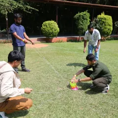 This activity requires delicate coordination and clear communication to move the object without dropping it. It is a perfect example of how our games mirror the collaborative challenges of the workplace.