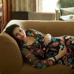 Another perspective from the same maternity shoot, showing a wider angle of the pose. This composition highlights the beautiful drape of the dress and creates a relaxed, reclining portrait that feels both glamorous and natural.