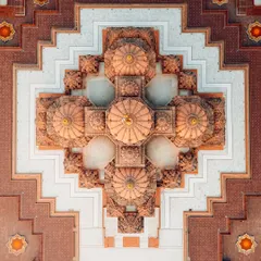A top-down, abstract view of the architecture of Akshardham Temple in Delhi. This drone shot reveals the incredible symmetry and detail of the temple's domes and patterns.