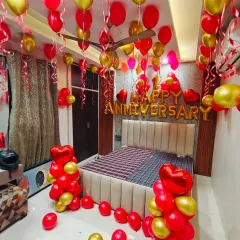 For a classic and romantic surprise, I can transform your bedroom with a full decoration package. This setup includes red and gold latex balloons, "Happy Anniversary" foil lettering, heart-shaped balloon bouquets, and ribbons hanging from the ceiling.