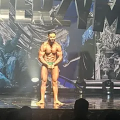 A front relaxed pose on stage in Korea. Even in a "relaxed" pose, every muscle must be engaged and conditioned to display a complete physique, a key part of the stage presence I teach my clients.