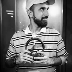 A black and white portrait holding my headphones. They are the most important tool of my trade, connecting me to the music and the audience.