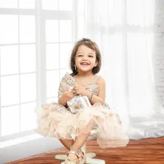 A beautiful, engaging smile. Seated on a simple stool, this little girl's happy face is the star of this classic and timeless portrait.