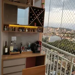 A compact yet comprehensive bar unit designed for a smaller balcony. It includes a mirrored back, a built-in wine rack, and under-cabinet lighting to highlight the glassware. The design also incorporates a safety net, showing how we combine functionality with safety.