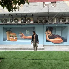 The completed 3D illusion mural in its cafe setting. The artwork is designed to interact with the space and the people in it, making it a landmark for visitors.