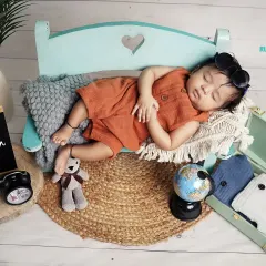 Three months old and ready to travel the world. This cute setup with a globe and suitcase is perfect for capturing this adventurous milestone.