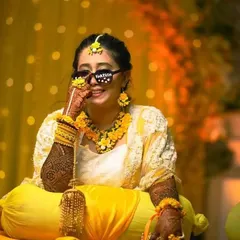 A fun and stylish bride at her haldi ceremony, rocking cool sunglasses and our full-arm bridal mehndi.