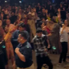 A blurry but energetic shot of the packed dance floor at a wedding. Everyone is moving to the beat.