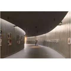 The gentle curve of the memorial's main gallery creates a flowing, continuous path for visitors. The design is intentionally minimalist to keep the focus on the photographs and the story they tell, creating a space for quiet reflection.