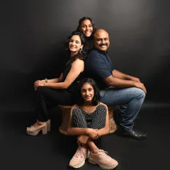A classic and elegant family portrait. Posing everyone together against a simple dark background creates a timeless image that focuses on the expressions and bond between family members.