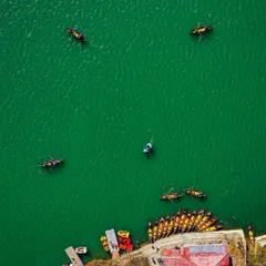 An aerial top-down perspective of the iconic Naini lake. This shot highlights the vibrant green of the water and the colorful boats, demonstrating a keen eye for composition and color that turns a familiar scene into a piece of art.