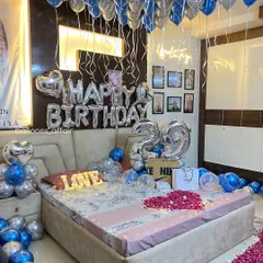 This angle showcases the density of the ceiling balloons and the custom neon sign, which adds a modern touch to the classic birthday balloon decoration.