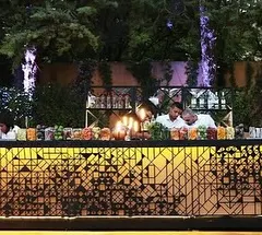 For this wedding, I designed a sophisticated bar with a custom geometric laser-cut facade. The backlighting made the pattern glow, adding a touch of modern elegance to the outdoor reception.