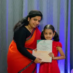 A young student proudly holds her music exam certificate. I provide a clear pathway for students to achieve internationally recognized qualifications.
