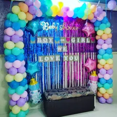 A classic "Boy or Girl" baby shower backdrop. This setup features a pastel balloon arch, a split blue and pink shimmer curtain, and a banner that reads "Boy or Girl, We Love You."