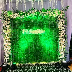 This lush green foliage wall with a custom neon hashtag is a classic and popular choice for a Sangeet or reception photo booth. The hanging fairy lights and wisteria add a touch of magic.