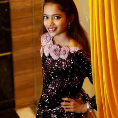 A young girl dressed up for a party, posing confidently for the camera. I enjoy capturing the personalities of children at events.