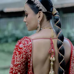 The back view is just as important. The sleek, modern braid is the perfect complement to the traditional lehenga and the classic makeup look.