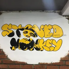 We painted this custom 'Stoned Monkey' graffiti logo directly onto an exposed brick wall for an ice cream parlor. This style of art adds a cool, urban vibe that matches the brand's identity.