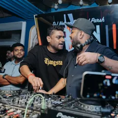 A candid moment of collaboration behind the decks. Working with other DJs is a great way to bring diverse sounds and a fun, shared energy to the party.
