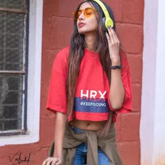 Capturing a cool, music-loving vibe on the street. The combination of the headphones, sunglasses, and casual HRX crop top creates a portrait that is full of personality and modern athletic style.