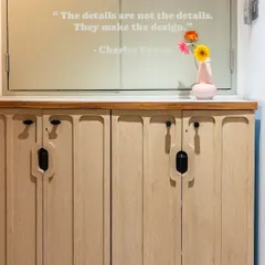 This entryway shoe rack is designed with slim, grooved doors and a marble top, providing essential storage while maintaining a sleek and modern look. The quote from Charles Eames reminds us that details make the design.
