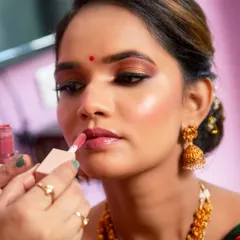 The art of makeup in progress. Here I am applying a soft nude lipstick to complete this dreamy, glowing look.